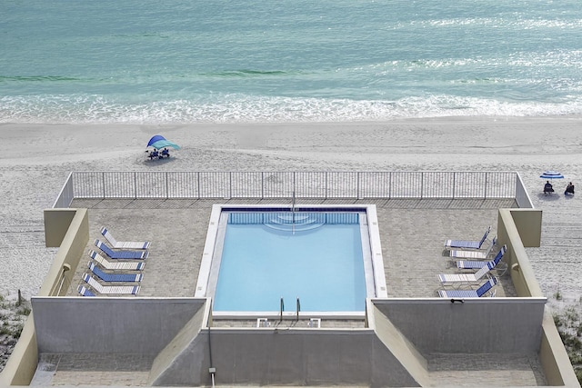 community pool featuring a view of the beach and a water view