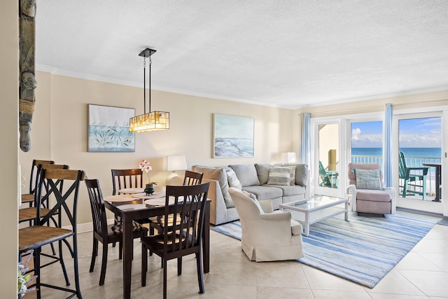 dining space featuring ornamental molding, a water view, a textured ceiling, and light tile patterned floors