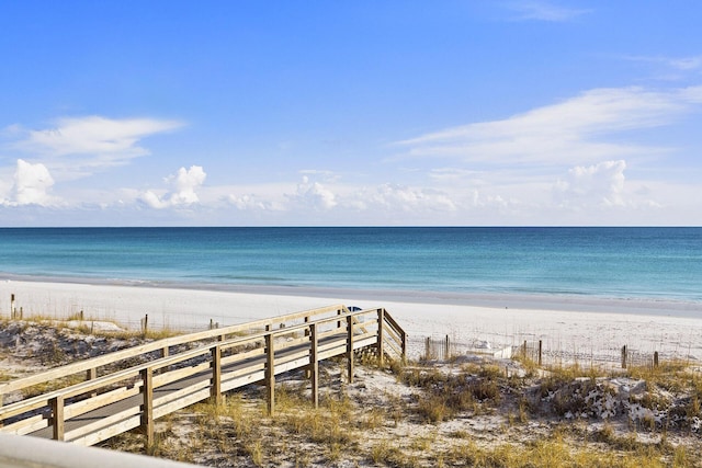 view of water feature with fence and a beach view