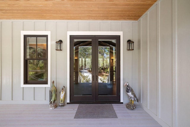 property entrance with board and batten siding and french doors