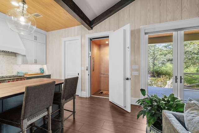 dining room featuring dark wood finished floors, visible vents, plenty of natural light, and lofted ceiling with beams