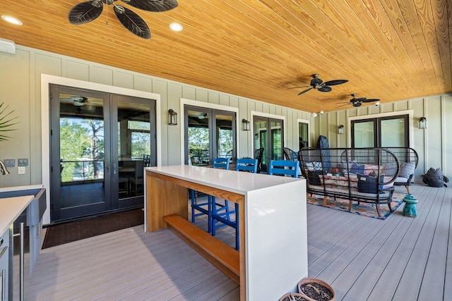 wooden deck featuring ceiling fan, french doors, and outdoor dry bar