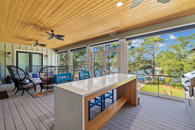 sunroom / solarium featuring wood ceiling and ceiling fan