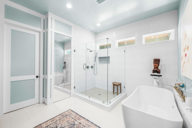 full bath with recessed lighting, a stall shower, a sink, a freestanding tub, and tile patterned floors