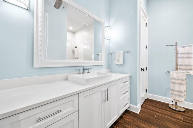 bathroom featuring visible vents, wood finished floors, vanity, and baseboards