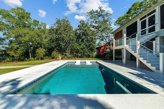 outdoor pool with a patio area and stairs