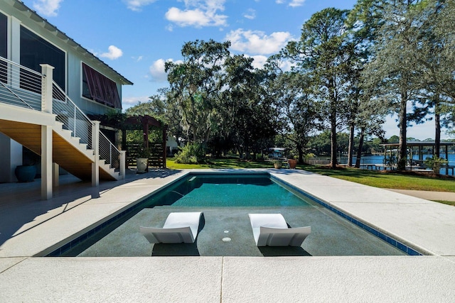 pool with stairway, a patio area, and a water view