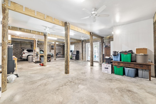 below grade area featuring a wood stove and a ceiling fan