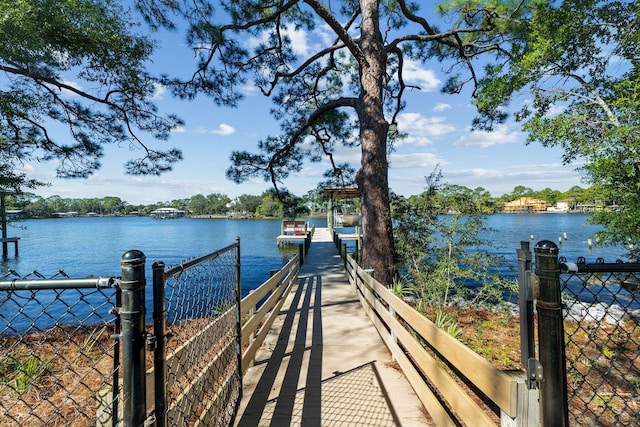 dock area with a water view and fence