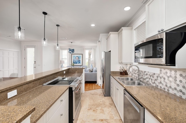 kitchen featuring sink, white cabinetry, decorative light fixtures, dark stone counters, and stainless steel appliances