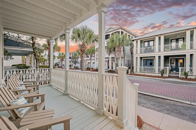 deck at dusk with french doors and covered porch