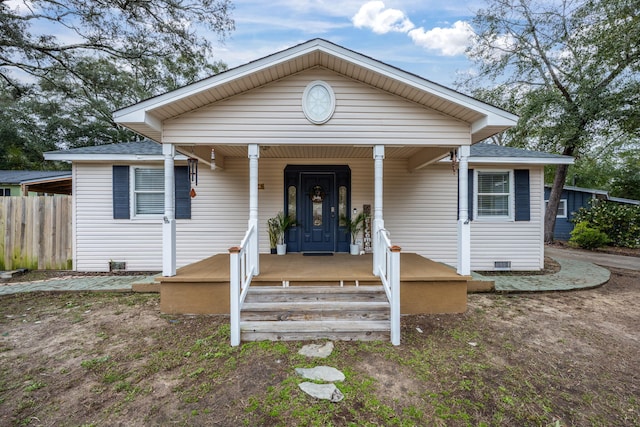 bungalow-style home featuring a porch, crawl space, a shingled roof, and fence