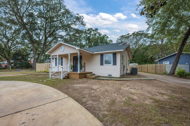 view of front of property featuring a shingled roof, crawl space, covered porch, fence, and central air condition unit