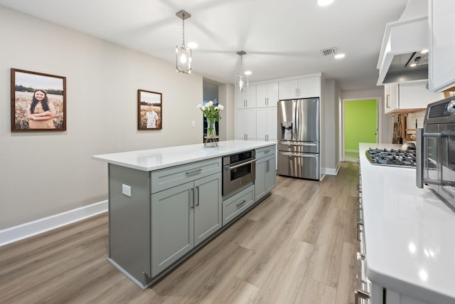 kitchen featuring stainless steel appliances, gray cabinets, light countertops, and visible vents