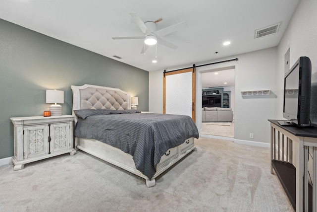 bedroom with a barn door, recessed lighting, light carpet, visible vents, and baseboards