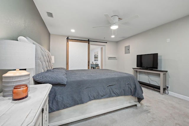 bedroom featuring recessed lighting, visible vents, a barn door, light carpet, and baseboards