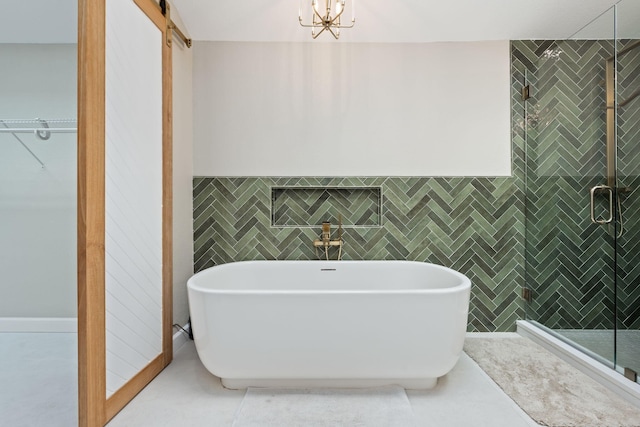 bathroom featuring a soaking tub, a shower stall, tile walls, and tile patterned flooring