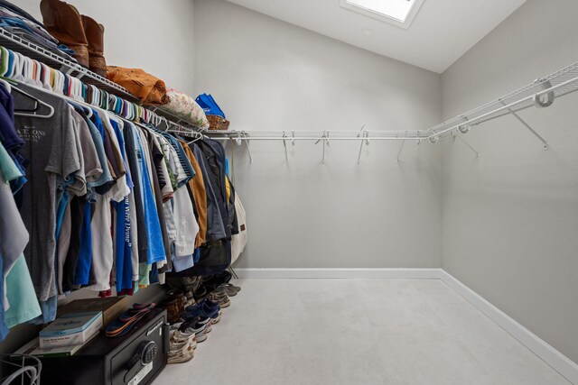 spacious closet with vaulted ceiling with skylight