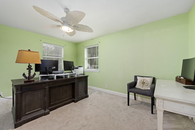 home office with baseboards, ceiling fan, and light colored carpet