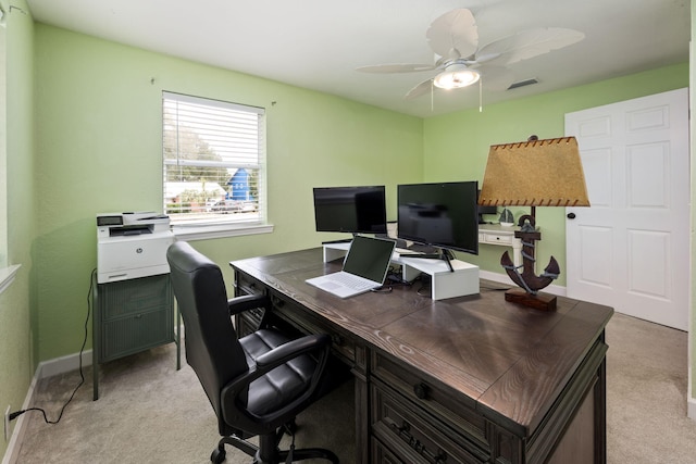 office space with a ceiling fan, light colored carpet, visible vents, and baseboards