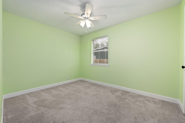 spare room with ceiling fan, carpet floors, and baseboards