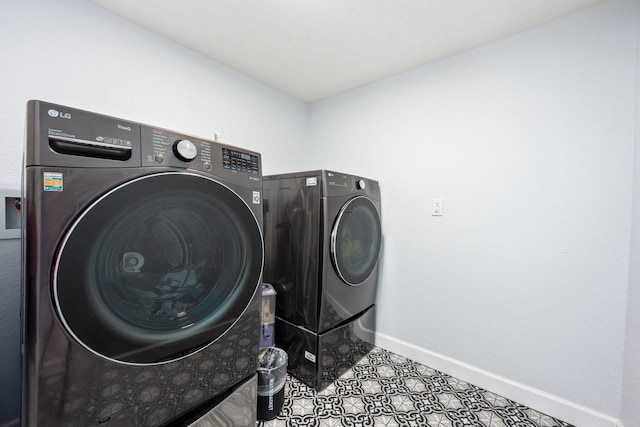 washroom featuring laundry area, washing machine and dryer, and baseboards