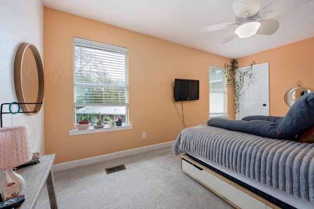 bedroom with carpet floors, multiple windows, visible vents, and baseboards