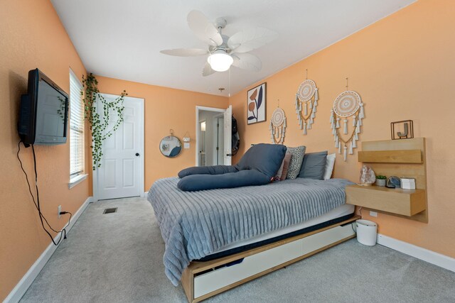 carpeted bedroom with baseboards, visible vents, and a ceiling fan