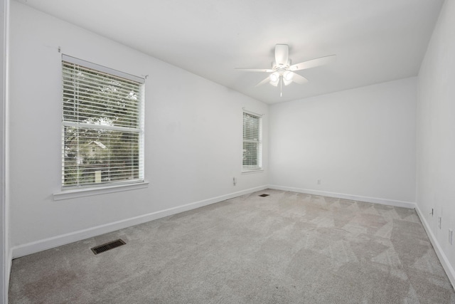 spare room with a ceiling fan, carpet, visible vents, and baseboards