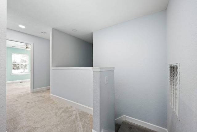 hallway featuring carpet, visible vents, and baseboards