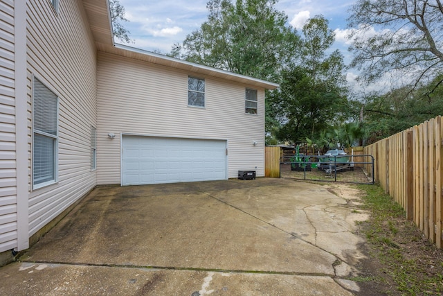 view of side of home with a garage and fence