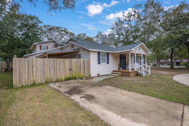 bungalow-style house featuring a porch, fence, a shingled roof, and a front lawn