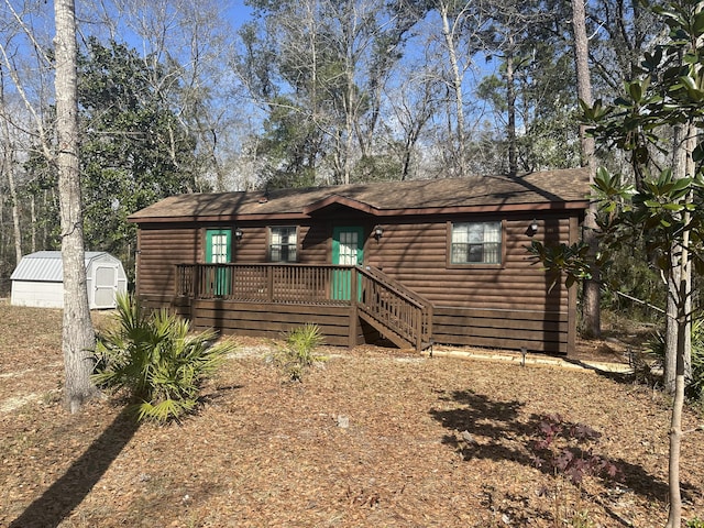 view of front of property with a storage shed, an outbuilding, and faux log siding