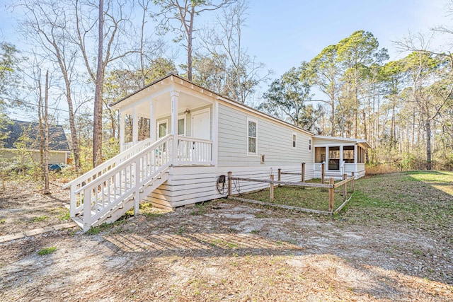 view of front of house with stairs and a sunroom