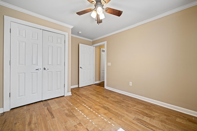 unfurnished bedroom featuring ceiling fan, baseboards, ornamental molding, a closet, and light wood finished floors