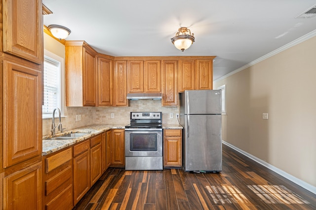 kitchen with stainless steel appliances, visible vents, a sink, light stone countertops, and under cabinet range hood