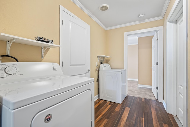 laundry room with dark wood finished floors, crown molding, washer and dryer, laundry area, and baseboards