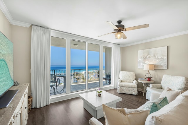 living area with a ceiling fan, dark wood-style flooring, a water view, expansive windows, and crown molding