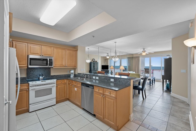 kitchen featuring sink, backsplash, stainless steel appliances, light tile patterned flooring, and kitchen peninsula