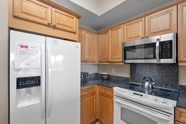 kitchen with dark stone countertops, backsplash, and white appliances