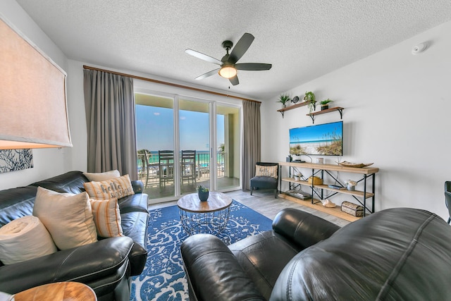 living area featuring ceiling fan, a textured ceiling, and wood finished floors