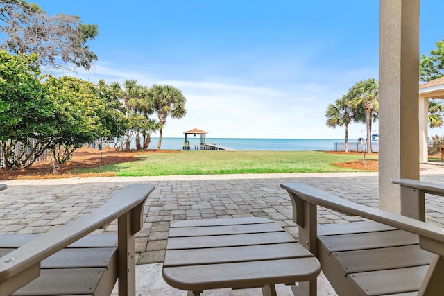 view of property's community with a water view, a patio, playground community, and a yard