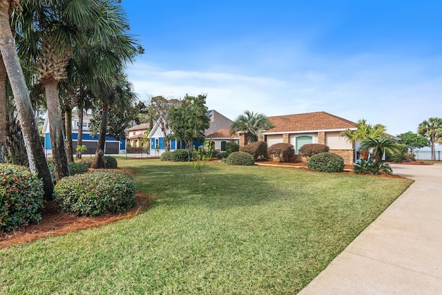 view of front of home featuring driveway, a garage, fence, and a front yard