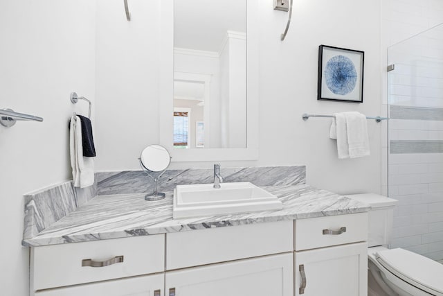 bathroom with crown molding, vanity, toilet, and walk in shower