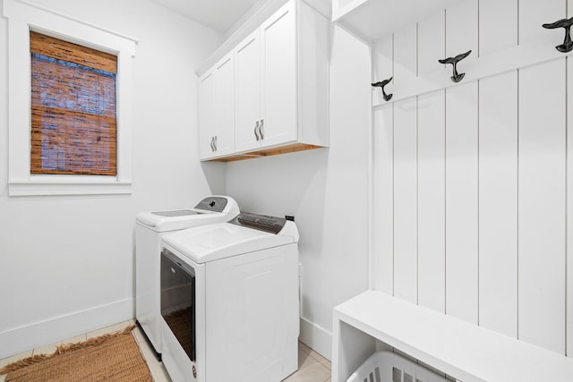 clothes washing area with cabinets and washer and dryer