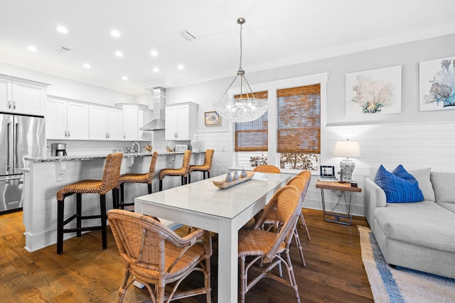 dining room featuring ornamental molding, dark hardwood / wood-style floors, sink, and a chandelier