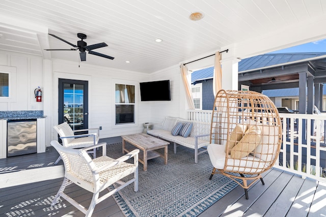 wooden deck featuring an outdoor living space and ceiling fan