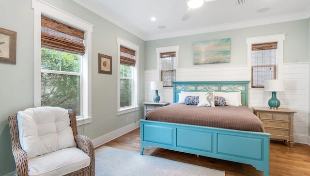 bedroom with ceiling fan, ornamental molding, and hardwood / wood-style floors