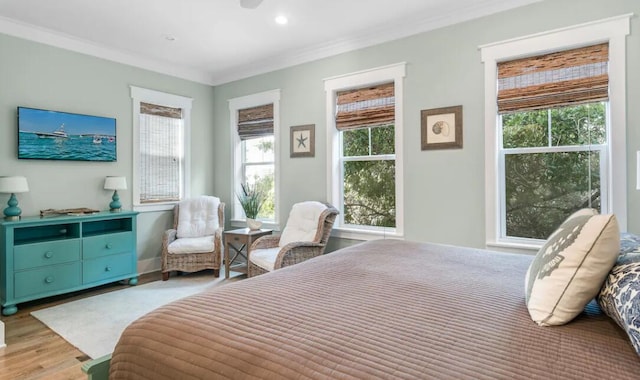 bedroom with ornamental molding and light hardwood / wood-style flooring