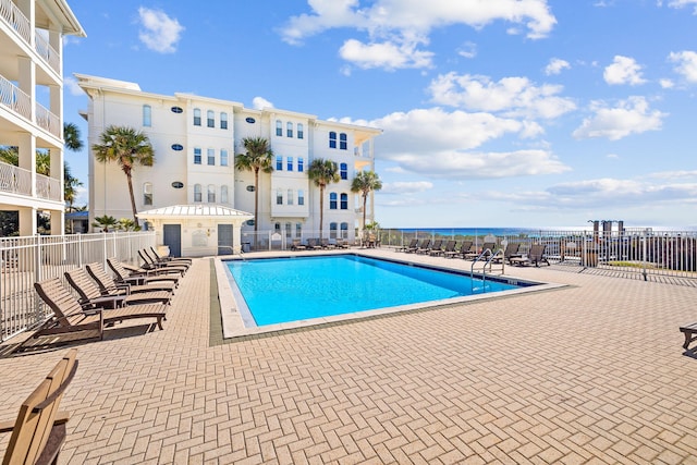 view of swimming pool with a patio and a water view